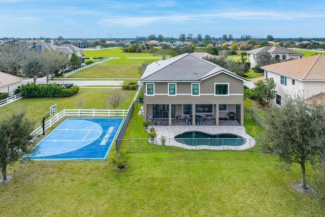 back of house featuring a lawn and basketball court