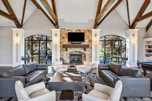 living room with a wealth of natural light, wood-type flooring, and high vaulted ceiling