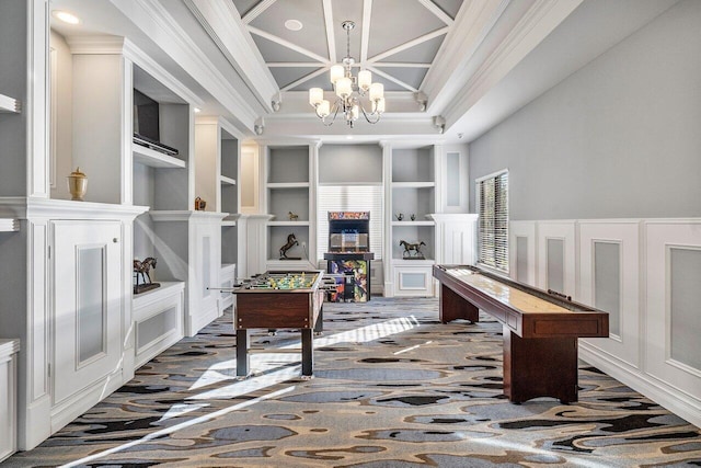 carpeted office space featuring a chandelier, built in shelves, crown molding, and a high ceiling