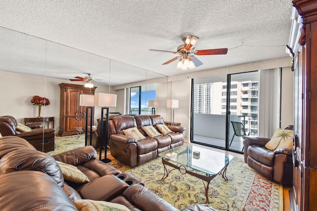 living room with a textured ceiling and ceiling fan