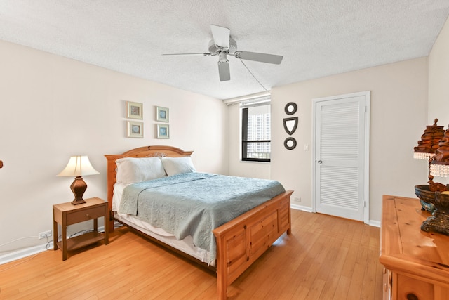 bedroom featuring ceiling fan, a textured ceiling, and light wood-type flooring