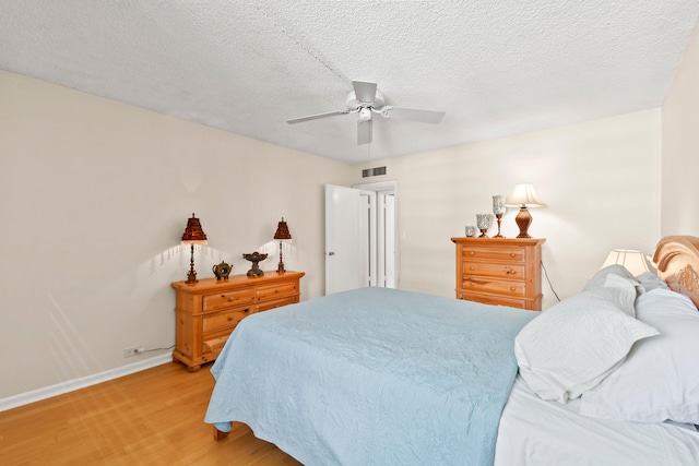 bedroom featuring wood-type flooring, ceiling fan, and a textured ceiling