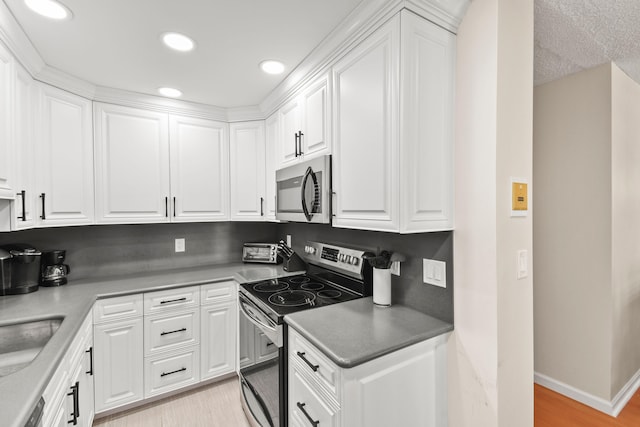 kitchen featuring white cabinets, stainless steel appliances, and light hardwood / wood-style floors