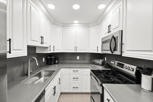 kitchen featuring white cabinets, sink, appliances with stainless steel finishes, and backsplash