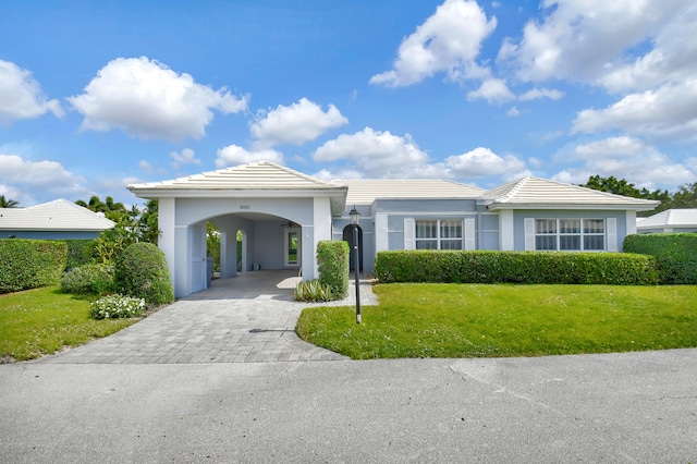 ranch-style home featuring a carport and a front lawn