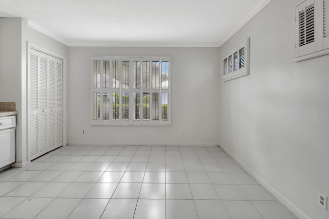 empty room with ornamental molding and light tile flooring