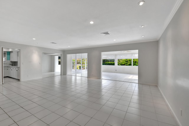 tiled spare room featuring plenty of natural light and ornamental molding