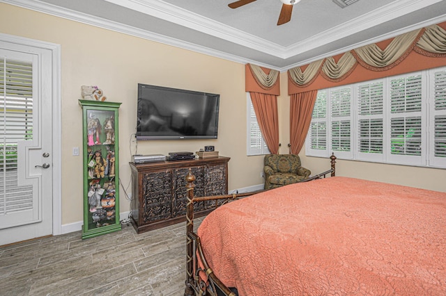 bedroom featuring multiple windows, wood-type flooring, ceiling fan, and ornamental molding