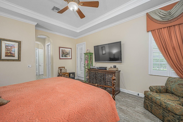 bedroom with wood-type flooring, ceiling fan, and ornamental molding