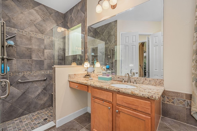 bathroom with tile patterned flooring, vanity, and tiled shower