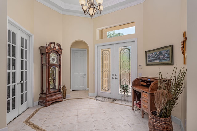 tiled living room featuring french doors, ceiling fan with notable chandelier, and ornamental molding