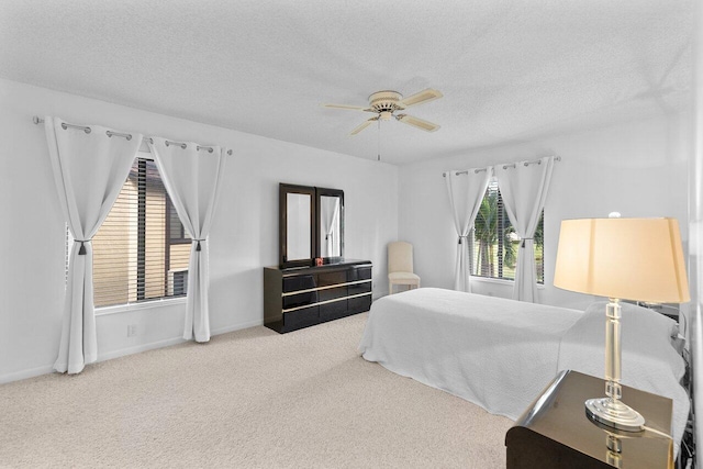 carpeted bedroom featuring ceiling fan and a textured ceiling