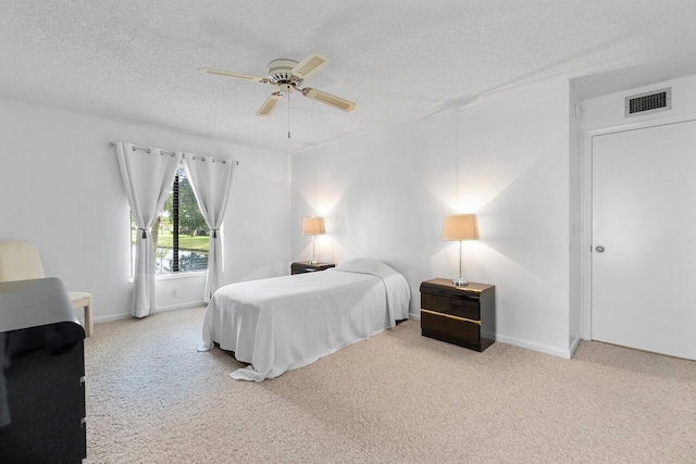 carpeted bedroom with a textured ceiling and ceiling fan