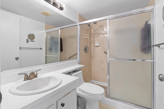 bathroom featuring tile floors, vanity, toilet, and a shower with shower door