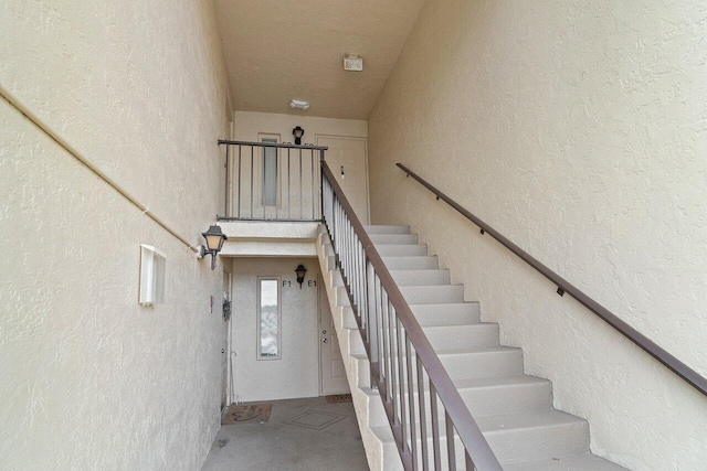 staircase featuring concrete flooring