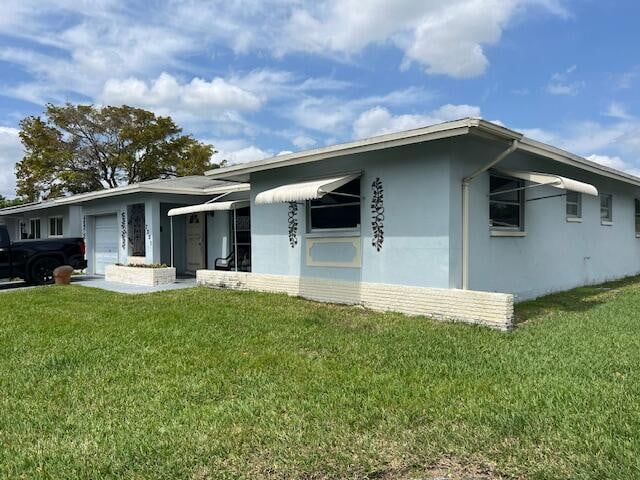 rear view of property featuring a yard and a garage