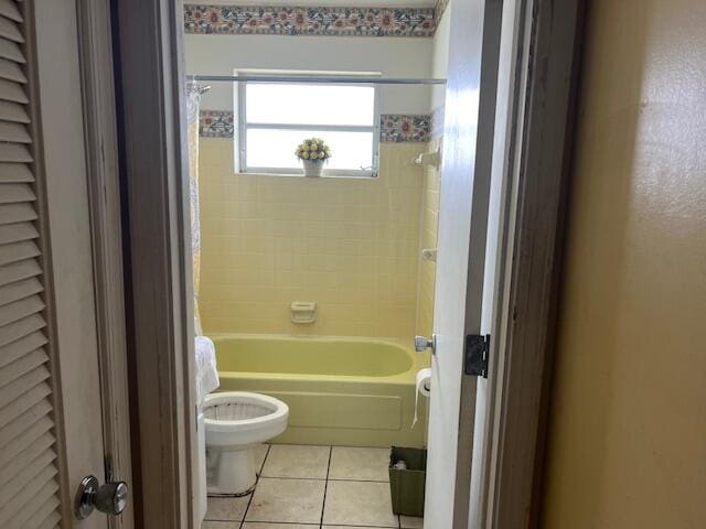 bathroom featuring tile flooring, shower / tub combo, and toilet