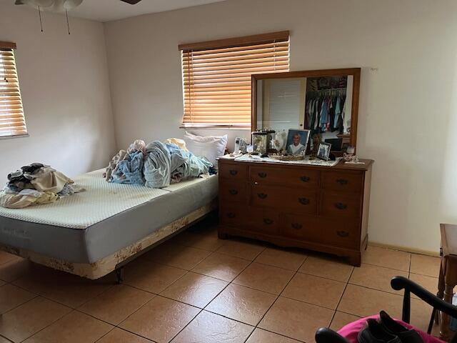 bedroom featuring ceiling fan and light tile floors