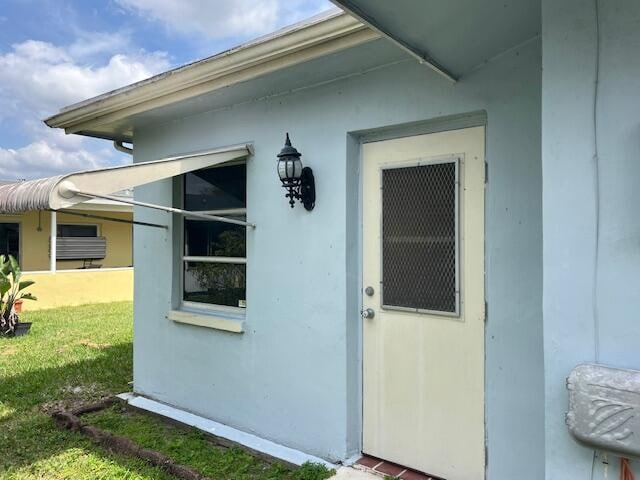 entrance to property with a lawn