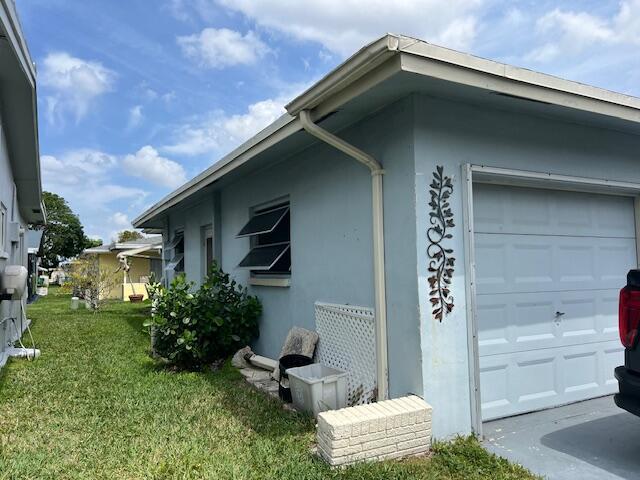 view of side of property with a garage and a lawn