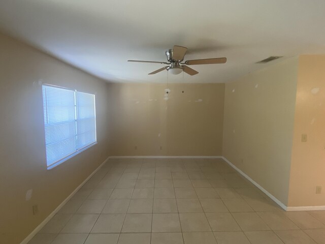 tiled spare room featuring ceiling fan