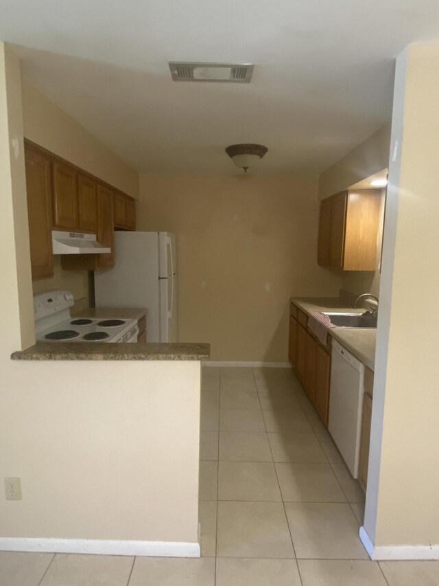 kitchen featuring sink, light tile patterned floors, and white appliances