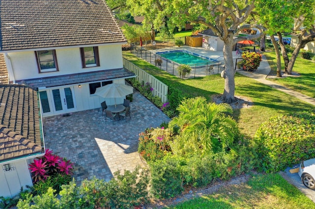 exterior space featuring outdoor dining space, a patio area, a fenced backyard, and a fenced in pool