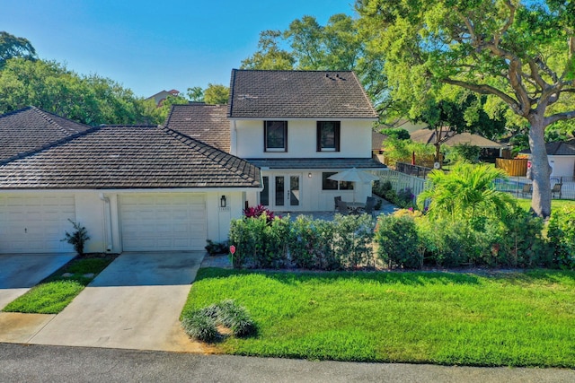 view of front of property featuring a garage, concrete driveway, fence, a front lawn, and stucco siding