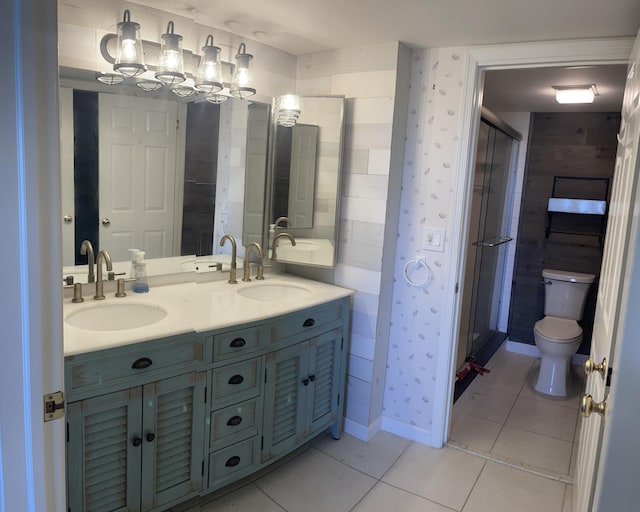 bathroom with a sink, toilet, and tile patterned floors