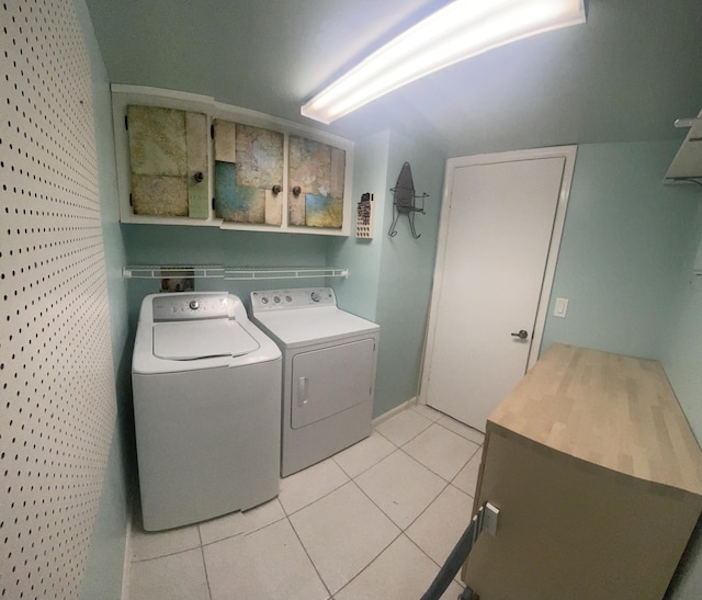 laundry room featuring light tile patterned floors, cabinet space, and separate washer and dryer