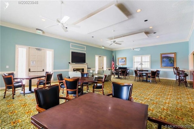 dining area with carpet floors, a fireplace, crown molding, and ceiling fan