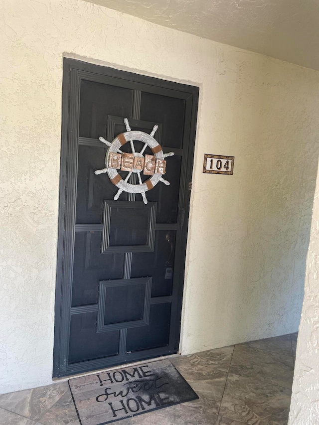 entrance to property with stucco siding