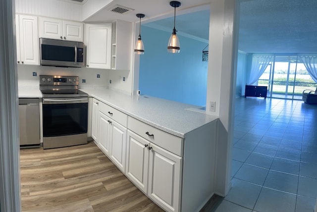 kitchen featuring white cabinetry, visible vents, appliances with stainless steel finishes, and ornamental molding