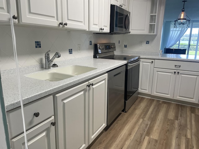 kitchen featuring tasteful backsplash, electric range, white cabinets, dark wood-style floors, and a sink