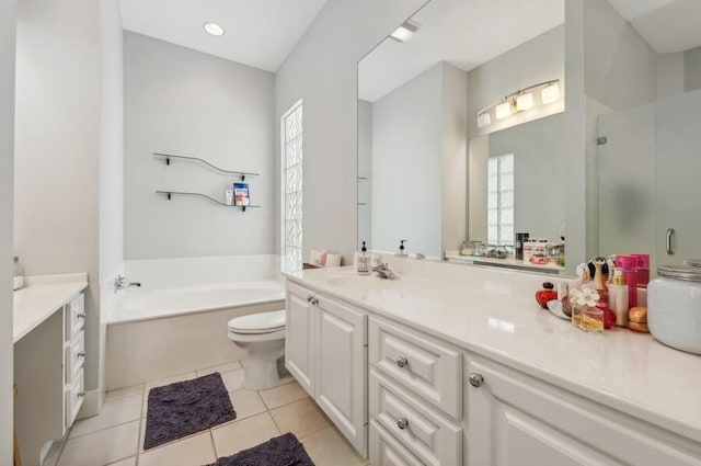 bathroom featuring tile flooring, a bathing tub, plenty of natural light, and vanity