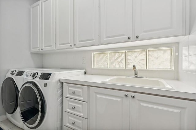 washroom with cabinets, sink, and washer and dryer