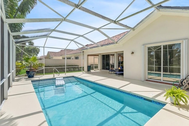 view of swimming pool featuring a patio area and glass enclosure