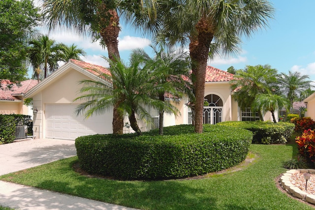 view of front facade with a garage and central air condition unit