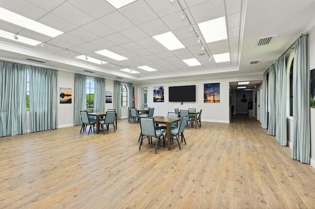 dining area with a drop ceiling and light wood-type flooring