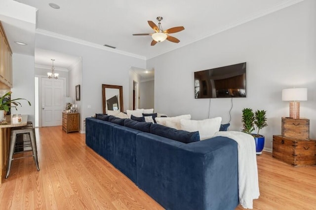 living room with ceiling fan with notable chandelier, crown molding, and light hardwood / wood-style floors