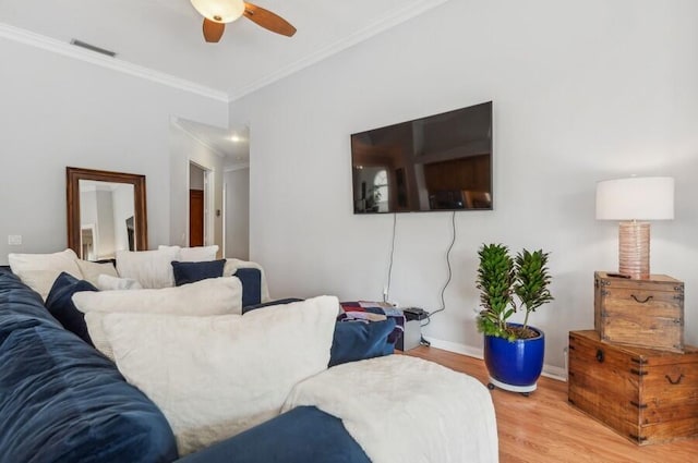 living room with hardwood / wood-style floors, ceiling fan, and crown molding