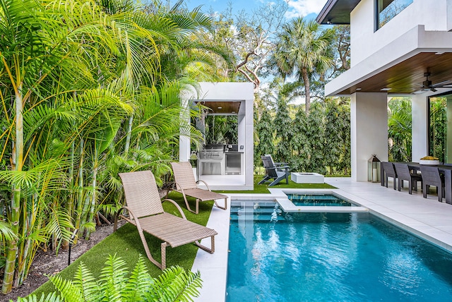 view of pool featuring a patio, an outdoor kitchen, ceiling fan, and an outdoor bar