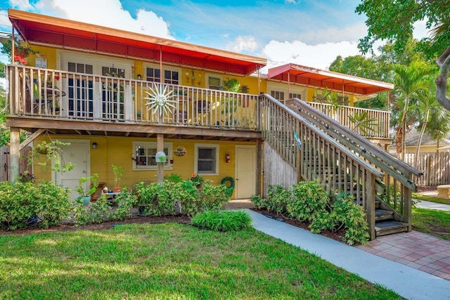 view of front facade featuring a wooden deck and a front lawn