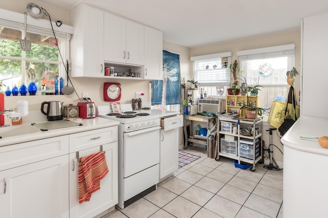 kitchen with white gas range, sink, light tile floors, and white cabinetry