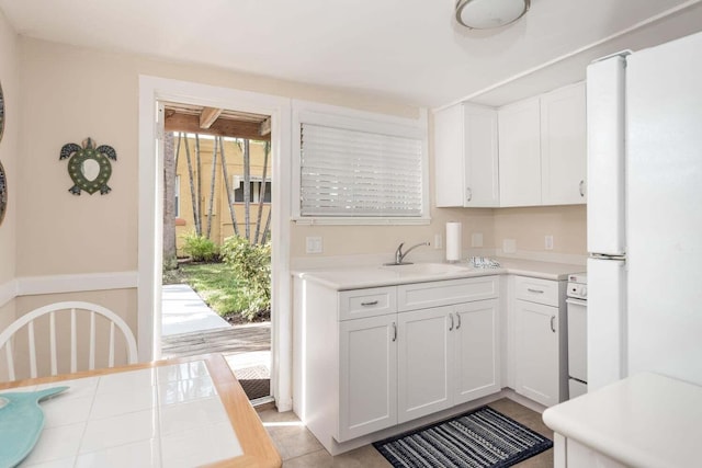 kitchen featuring white cabinets, sink, and a wealth of natural light