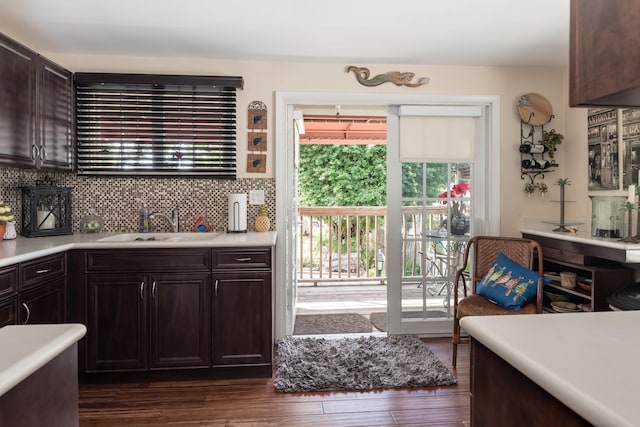 kitchen featuring backsplash, dark wood-type flooring, dark brown cabinetry, and sink