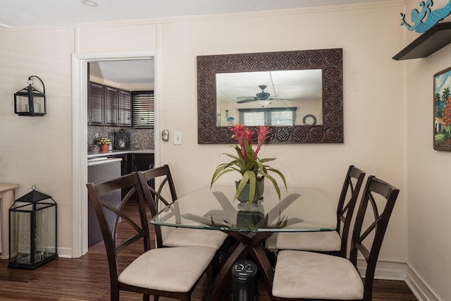 dining room with crown molding, ceiling fan, and dark hardwood / wood-style floors