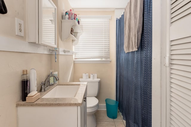 bathroom featuring vanity with extensive cabinet space, toilet, and tile floors