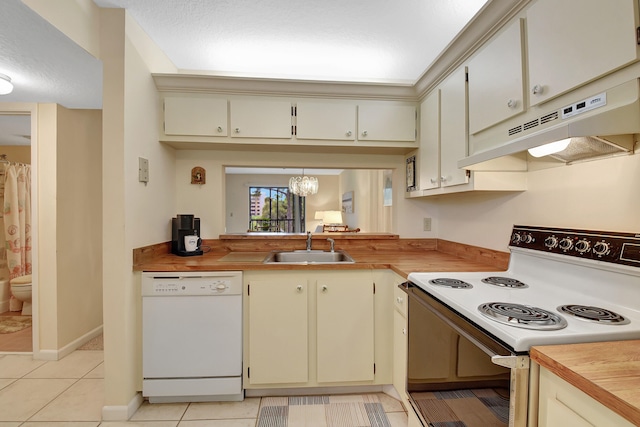 kitchen with white appliances, sink, cream cabinets, light tile patterned floors, and a notable chandelier