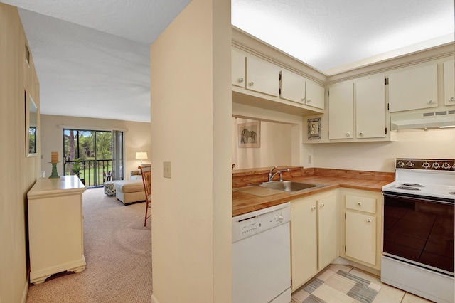 kitchen featuring light carpet, cream cabinets, white appliances, and sink